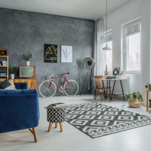 Simple wooden desk standing under windows in room with potted plants